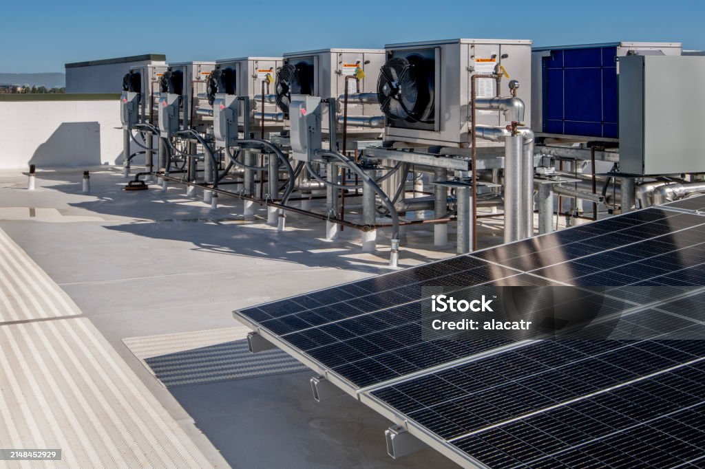 Rooftop commercial HVAC units and solar panels connected with electrical conduit and wiring