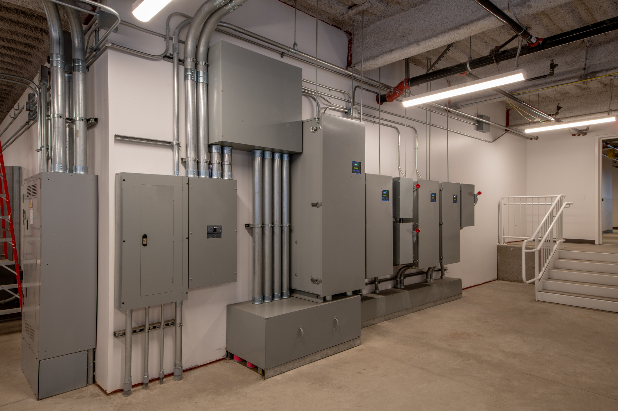 Commercial electrical distribution panels and metal conduit in a building electrical room