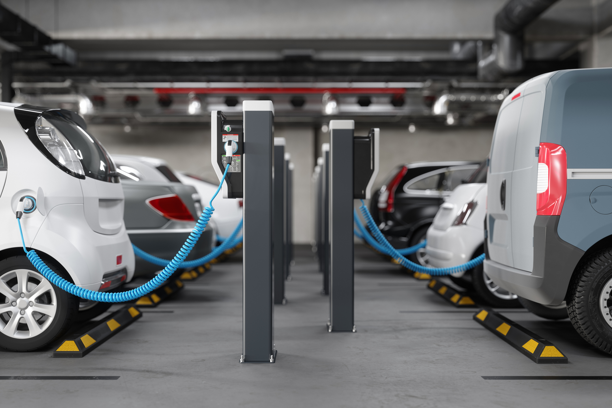 Electric vehicles charging at pedestals in an underground parking garage