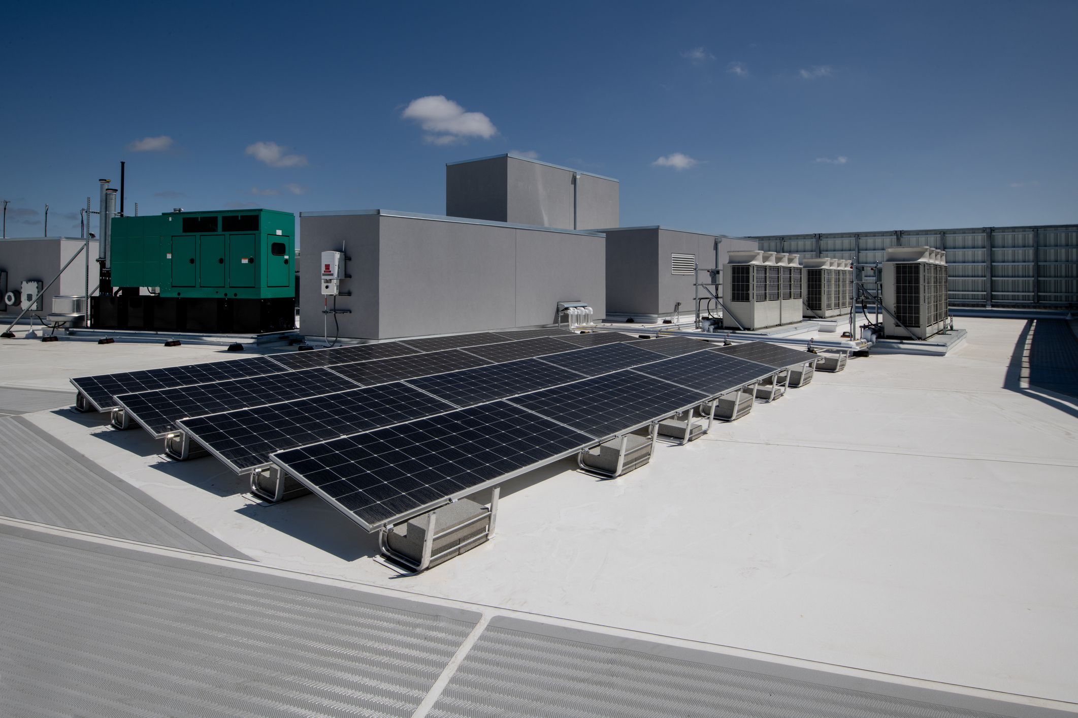 Rooftop solar panels, a standby generator, and HVAC units at a light industrial facility