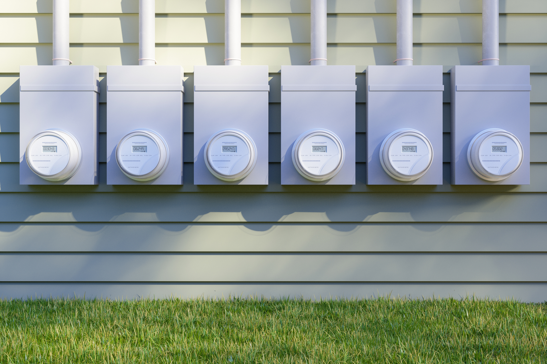 Row of electric utility meters mounted on the exterior siding of a multifamily building